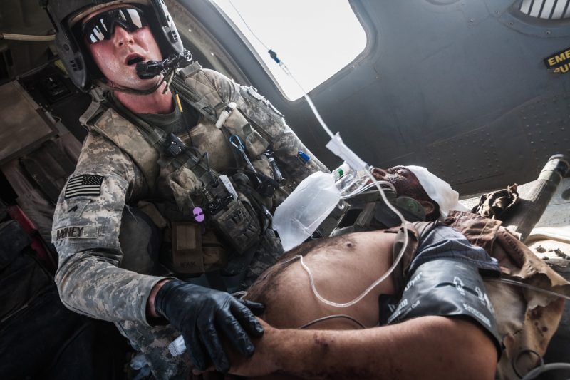 Der Flight Medic kümmert sich um einen schwer verwundeten afghanischen Polizisten, dessen Fahrzeug auf eine Sprengfalle gefahren war. (c) Simon Klingert